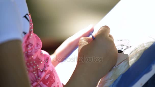 Klein meisje kind zit in het park, op een bankje en ricott-olieverf op doek-close-up - Video