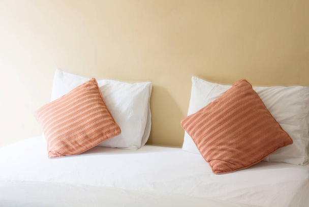 oreiller blanc et oreiller orange sur le lit et avec couverture dans la chambre vintage
 - Photo, image