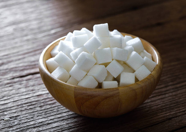 Sugar cubes in wood bowl on wood table - Foto, imagen