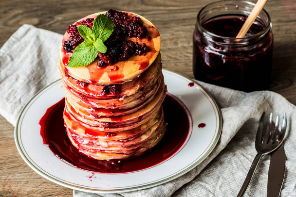 Stack of homemade american pancakes served with jam and strawberries on wooden background - Photo, Image