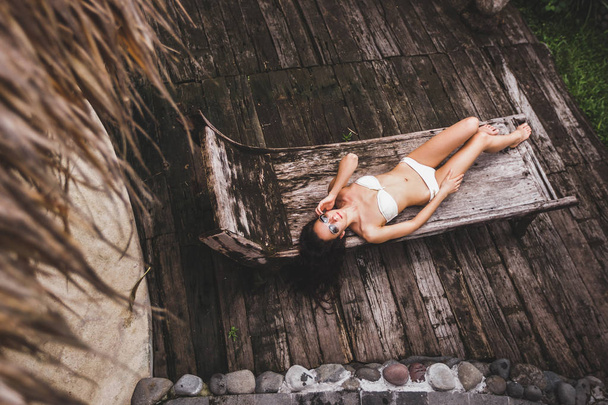 Woman on wooden chaise lounge - Foto, Imagem