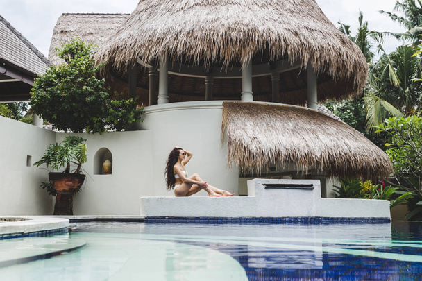 Mulher desfrutando perto da piscina
 - Foto, Imagem