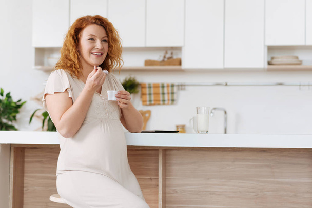 Full term pregnant woman enjoying delicious yogurt - Фото, зображення