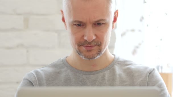 Hombre de mediana edad que trabaja en el ordenador portátil, Vista frontal
 - Imágenes, Vídeo