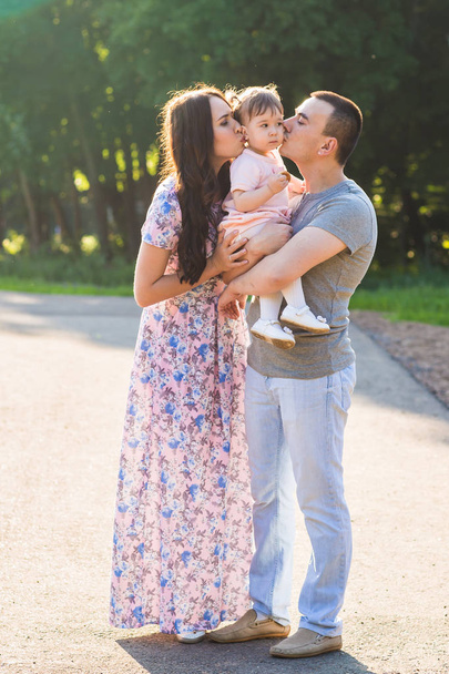 Parents kissing their small daughter outdoor in summer - Foto, Imagem