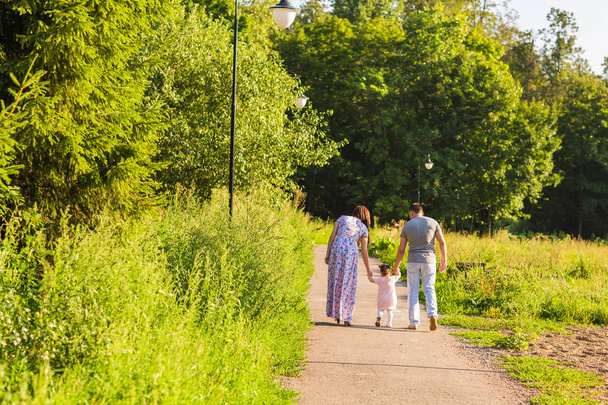 concept de famille, de parentalité et de personnes - mère heureuse, père et petite fille marchant dans un parc d'été
 - Photo, image