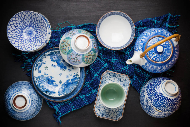 Keramik-Utensilien, Teller und Teekanne auf dem Tisch. Ansicht von oben - Foto, Bild