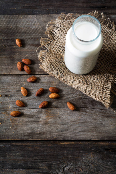 Almond milk on wooden table - Фото, зображення