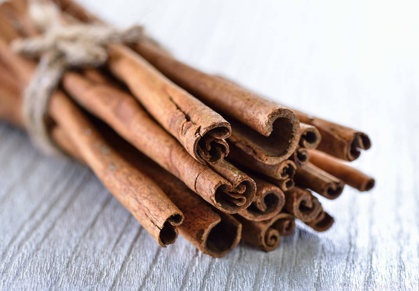 Cinnamon on white wood - Photo, Image