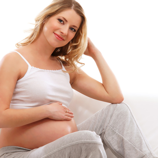 Young attractive pregnant woman on the sofa - Фото, зображення