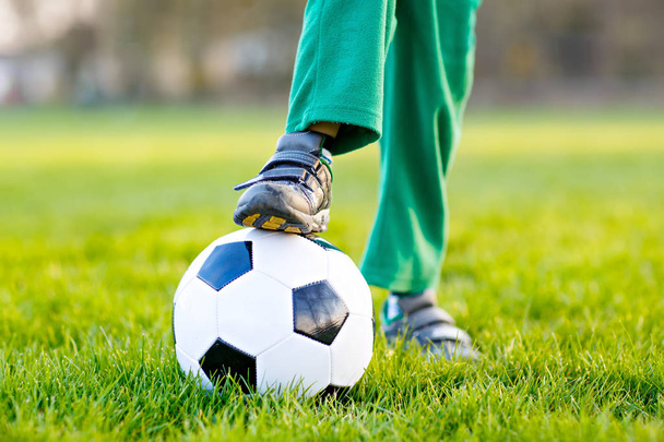 Kis aranyos gyerek fiú 4 fociznak a labdarúgó pályán, szabadban - Fotó, kép