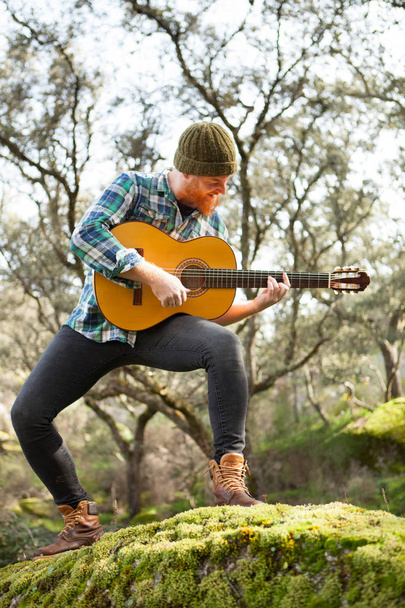 handsome man with guitar in nature - Photo, Image
