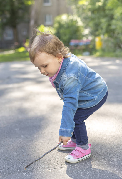 Маленька красива дівчинка досліджує на тротуарі
 - Фото, зображення