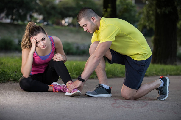 Man helps to woman with injured knee - Фото, зображення