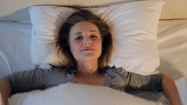 Happy smiling woman going to sleep. Close-up. 4K. - Materiał filmowy, wideo