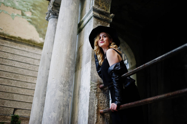 Blonde woman on black dress, leather jacket, necklaces and hat a - 写真・画像