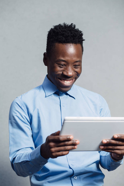 African american man in blue shirt using tablet PC - Photo, Image