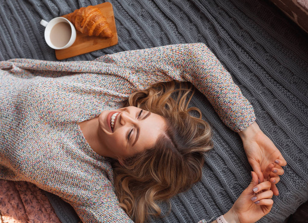 Cheerful woman on bed - 写真・画像
