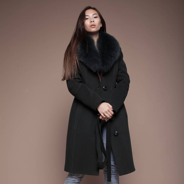 Winter Woman in Luxury Fur Coat. Fashion asian model om beige background. - Foto, immagini