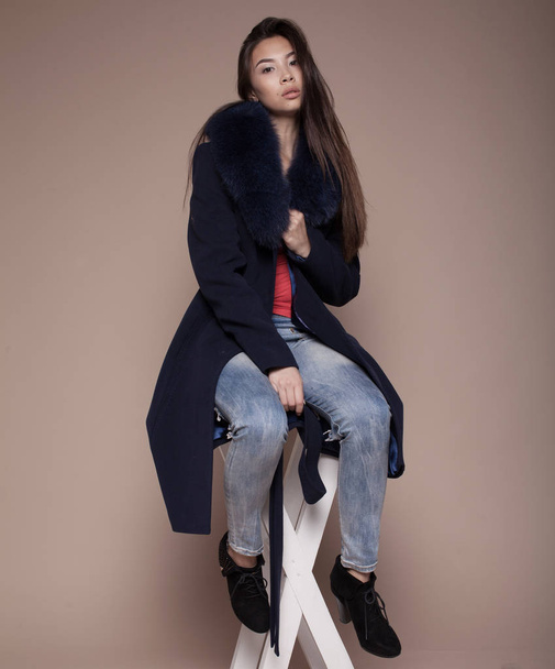 Winter Woman in Luxury Fur Coat. Fashion asian model om beige background. - Фото, изображение
