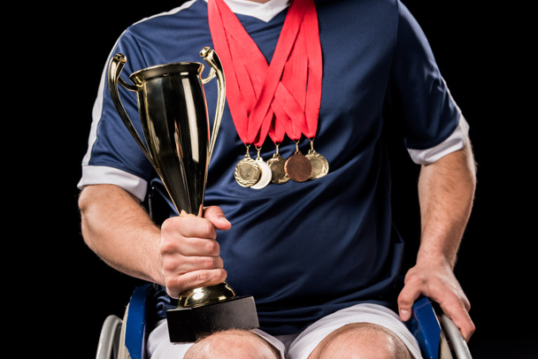 paralímpico en silla de ruedas con trofeos
 - Foto, Imagen