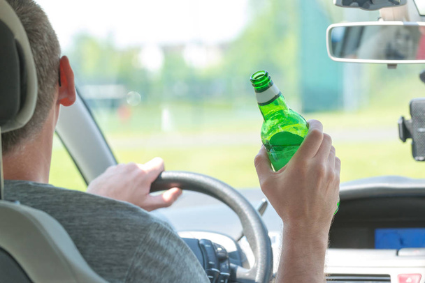 Hombre bebiendo cerveza mientras conduce un coche
 - Foto, imagen