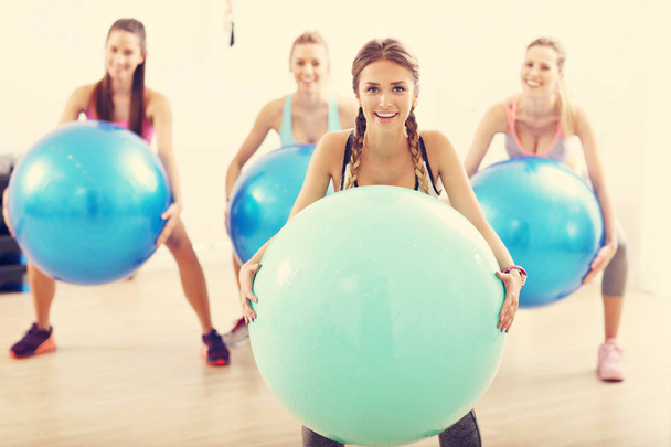 Grupo de personas sonrientes haciendo aeróbicos con bolas
 - Foto, Imagen
