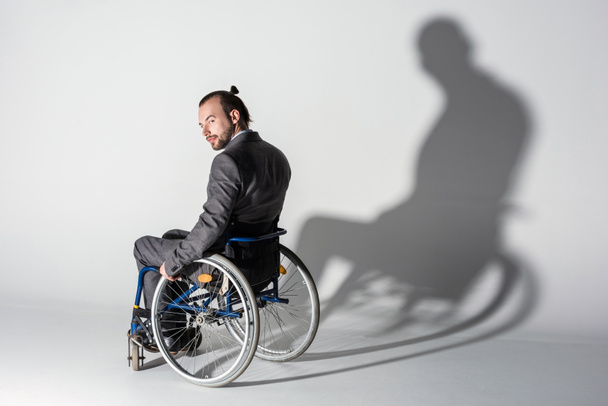empresário fisicamente deficiente em cadeira de rodas com sombra
 - Foto, Imagem