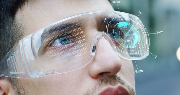 A man watches with a futuristic look with glasses augmented reality in holography. Concept: immersive technology, future, eyes, and futuristic vision. - Foto, Bild