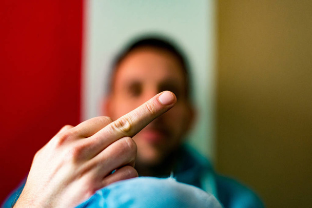 Middelste vinger van een man omdat hij niet wil om gefotografeerd te worden - Foto, afbeelding