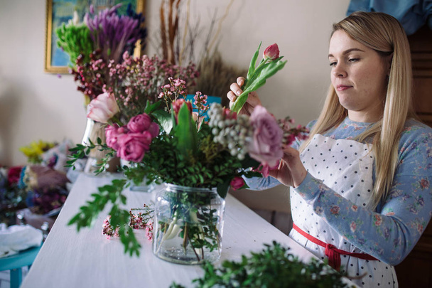 Female florist preparing bouquet - Foto, imagen