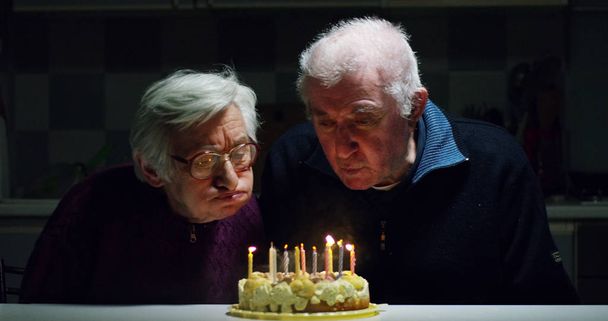 old tenderly couple at 90 birthday having fun with confetti and kissing in slow motion - Fotó, kép