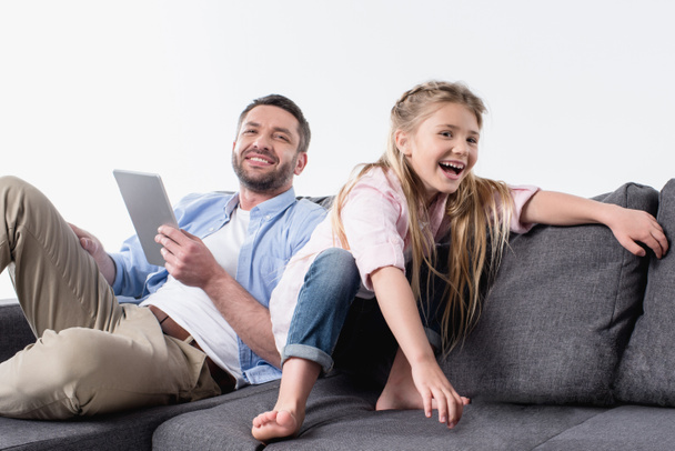 father with daughter sitting on sofa - Foto, afbeelding