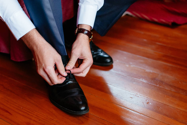 The groom ties up the shoelaces - Photo, Image