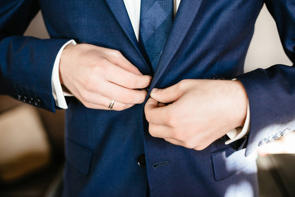man fastens his jacket. Groom getting ready. Businessman putting on his jacket - Photo, Image