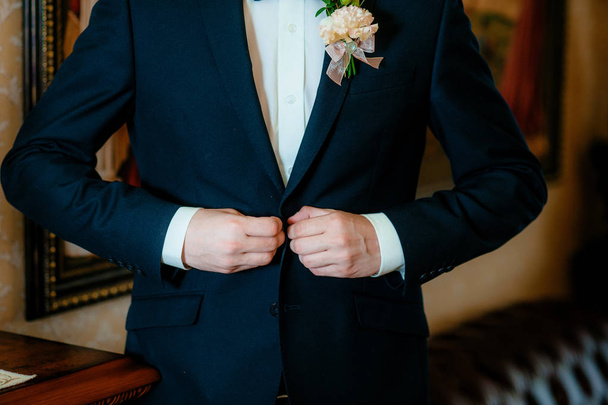 man fastens his jacket. Groom getting ready. Businessman putting on his jacket - Foto, imagen