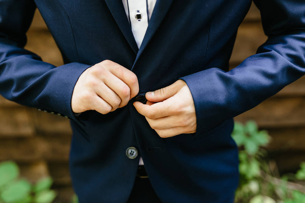 man fastens his jacket. Groom getting ready. Businessman putting on his jacket - Photo, image