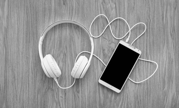 headphones and smartphone on wooden background - Fotoğraf, Görsel