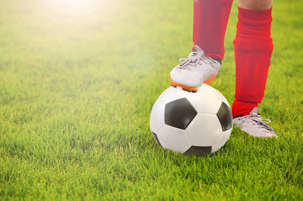 Detail malý chlapec nohy hraní fotbalu na fotbalové hřiště - Fotografie, Obrázek