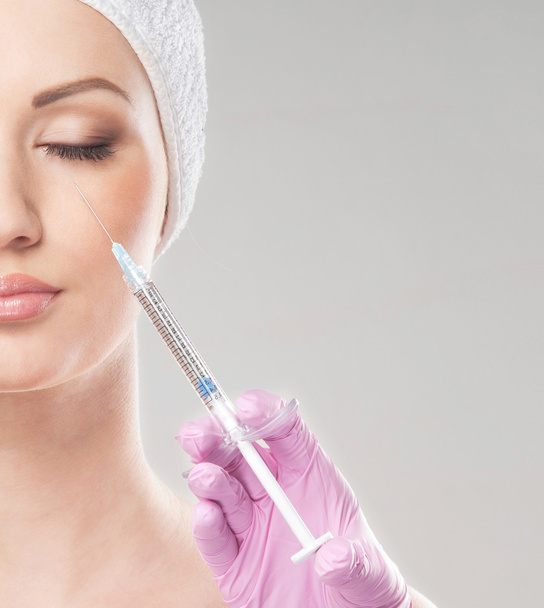 Beautiful woman gets an injection in her face - Foto, Bild