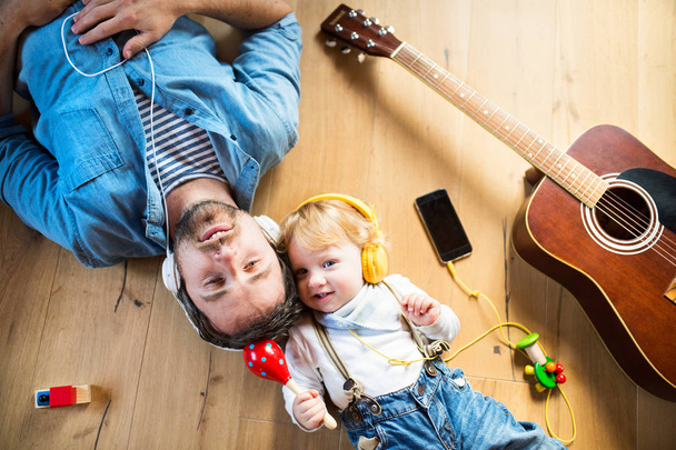 Father and son with smartphone and earphones, listening music. - Foto, Bild
