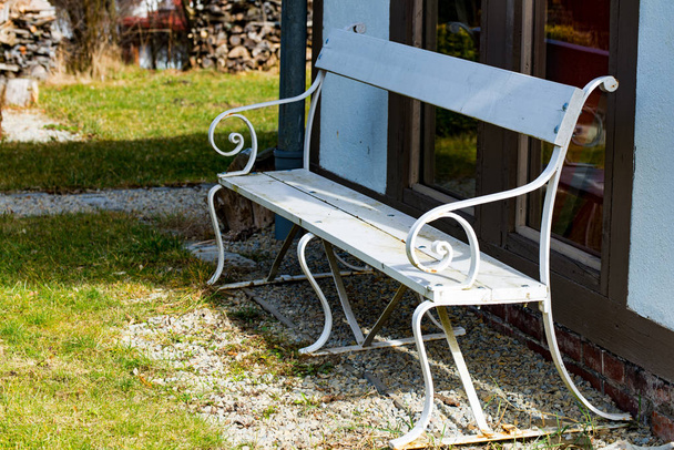 White park bench in the sun in the garden - 写真・画像