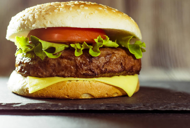 Peynir, marul ve domates bir taş ile lezzetli hamburger - Fotoğraf, Görsel