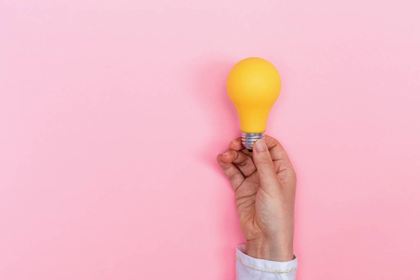 Person holding colored light bulb - 写真・画像