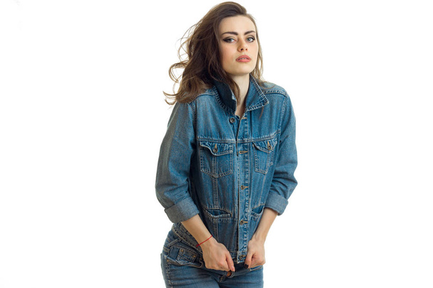 young beautiful girl in jeans suit stands up straight and looks in forward - Фото, зображення