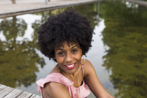 portrait d'une belle jeune femme afro-américaine heureuse assise
 - Photo, image