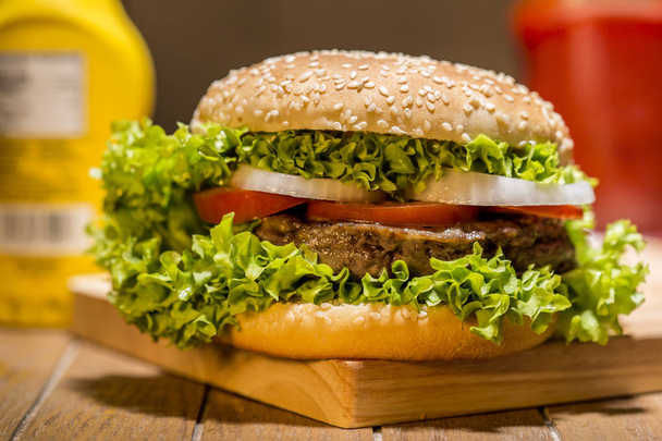 Delicious hamburger with vegetables on wooden board - Foto, immagini