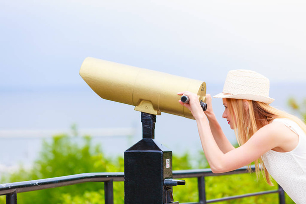 Woman tourist with sun hat looking through telescope - Photo, Image