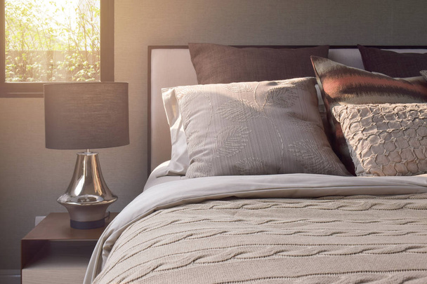 Eleganza cuscini stile impostazione su biancheria da letto in stile classico e lampada da lettura sul comodino-effetto luce solare
 - Foto, immagini