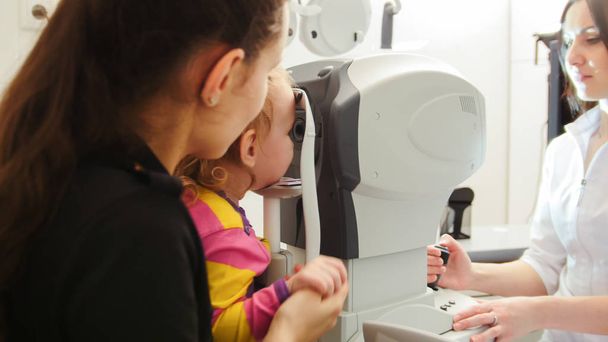Mãe com uma criança para consultar um oftalmologista
 - Foto, Imagem